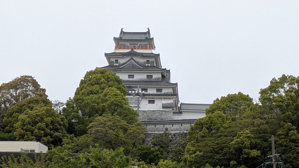 樹木越しに見上げる唐津城の模擬天守